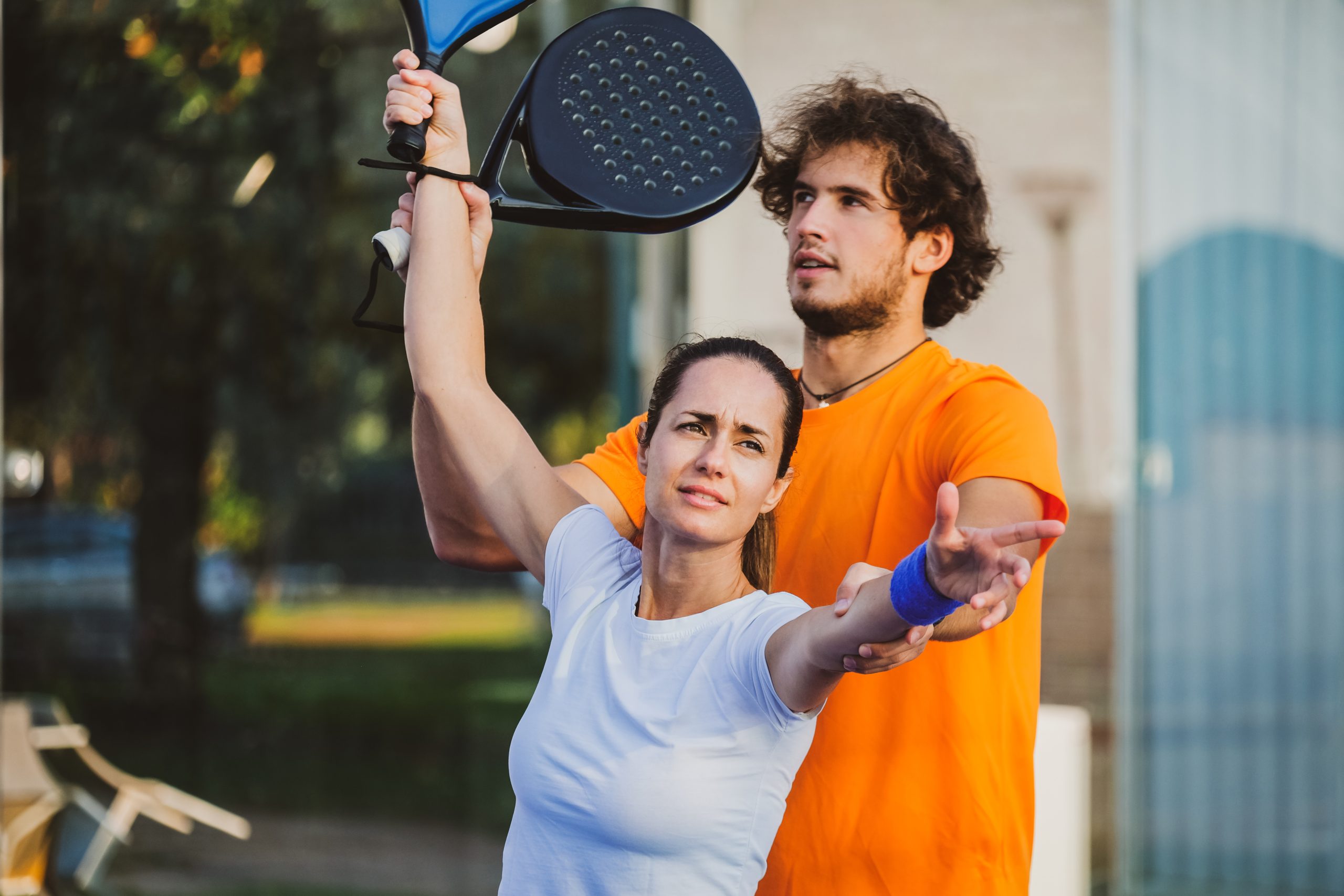 man teaching tennis woman scaled
